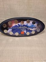 Front view of oval display with all twelve coins installed