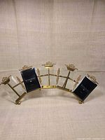 Front view of arched brass multi-photo frame showing five vertical openings and decorative details