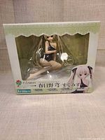 Front of boxed figure showing character in navy swimsuit through clear window