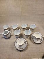 Overall group showing eight Wedgwood pieces: teacups, saucers, sugar bowls