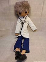 full view of doll seated showing all attire and accessories