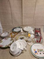 Group shot showing all mixed china pieces, figurine, glass dish and boxed cake server