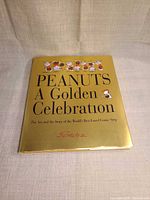 Front cover of Peanuts: A Golden Celebration hardcover with gold dust jacket
