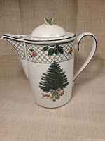 Front view of porcelain teapot displaying Christmas tree design and spout