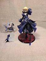 Full figure on base with sword, alternate arm and clear packaging visible