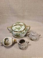 Group shot showing all four items: porcelain clover sugar bowl, ceramic sugar, ceramic creamer, painted ornament