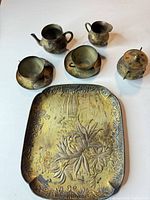 Top view of full tea set showing tray, teapot, creamer, sugar bowl with lid, two cups and saucers