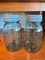 Front view of both Ball aqua jars with lids attached