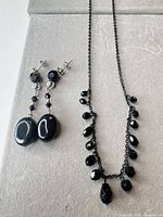 Necklace and earrings laid out together displaying overall design