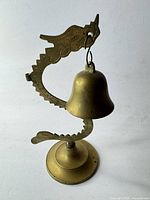 Full view of brass bell with dragon stand
