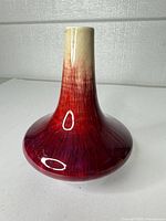 Full view of bottle-form porcelain vase showing cream neck and red-purple flambé body