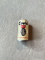Front view of miniature Coors can showing logo and Made in Hong Kong text