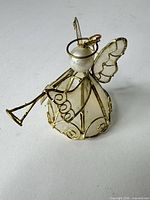 full view of angel ornament showing trumpet and mesh body