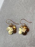 front view of both gold tone flower earrings on surface