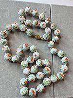Full view of necklace showing all porcelain beads and clasp