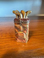 Front view showing golf club handles, marbled paint, metal hinge