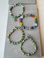 All four bracelets displayed on grey board