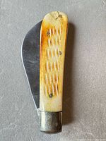 Full view of folded knife showing handle texture and blade shape