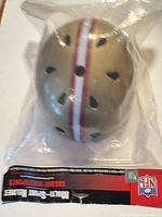 Top view of helmet in packaging showing gold color, stripes, vents