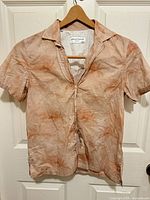 Front view of Officine Générale peach linen shirt on hanger