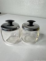 Both glass jars with lids front view