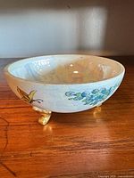 Side view showing hand-painted floral motif, butterfly and gold foot