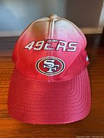 Front view showing embroidered team logo, gradient color, brim wear