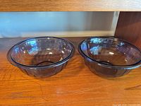 Both amethyst glass dishes side by side on shelf