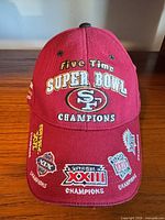 Front view showing embroidered 49ers logo, 'Five Time Super Bowl Champions' text and patch graphics