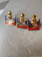 Front view of all three identical enamel lapel pins