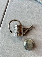 Watering can figurine and top hat token together