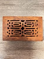 Top view showing carved pierced lid design on stained wood