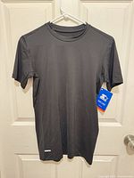 Front view of black Starter short sleeve T-shirt with retail tag