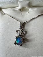 Front close-up showing opal teddy bear pendant on chain