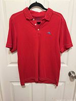 Full front view of red polo shirt on hanger