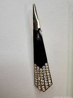 Full view of tapered black enamel and rhinestone brooch