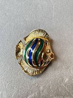 Front view showing fish design, enamel colours and gold-tone finish