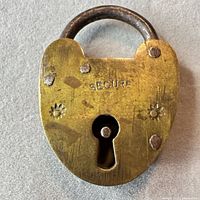 Front of brass padlock showing SECURE stamp and keyhole