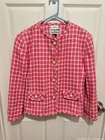 Full view of pink and ivory tweed jacket front hanging on door