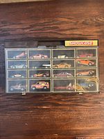Front view of display case showing 16 cars