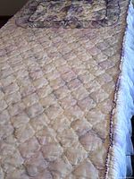 Full view of quilted bedspread surface and pillowcase on top