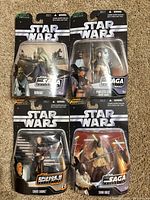 Front view of four sealed Hasbro Star Wars Saga Collection figures