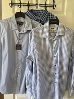 Three shirts grouped on hangers showing patterns and tag presence