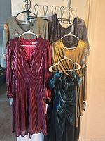 Group showing all five dresses on hangers