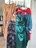 Group shot of five dresses hanging on door