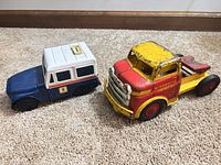 Both toy trucks side by side on floor