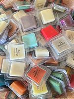 Pile of assorted coloured wax melt cubes in clamshells