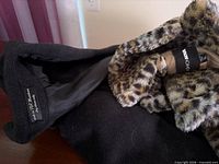 Close-up of brand label, wool exterior fabric and detachable leopard faux fur lining