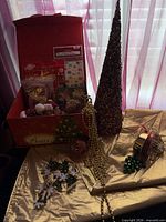 Overall lot with box, sequined tree, gold garland, tablecloth, snowflake cutouts visible