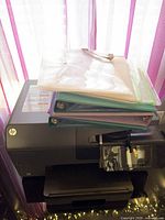 Printer with binders and mesh pouch stacked on top